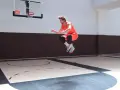 Atleta in aria, in pieno allenamento contro resistenza, su un campo da basket.