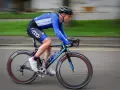 Ciclista in gara, i suoi muscoli delle gambe lavorano intensamente per spingere i pedali.