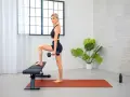 Donna esegue step-up con manubrio, allenando il vasto laterale coscia.