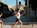 Corridori in città, un uomo corre con un semaforo pedonale verde. Il **talk test** è superato, respira bene.