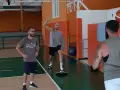 Allenamento in palestra: un uomo esegue torsioni del busto su una tavoletta di equilibrio, mentre un altro lo osserva.