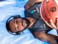 Giocatore di basket con cuffie e pallone, pronto per la preparazione fisica.