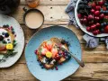 Toast con frutta fresca e yogurt, una colazione energetica per sportivi. Frutti di bosco, fragole e ciliegie per iniziare la giornata con vitalità.