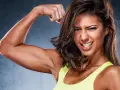 Donna mostra i suoi bicipiti scolpiti, un esempio di cosa sono i bicipiti, con un'espressione determinata.