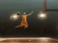 Un giocatore di basket in aria, pronto a schiacciare, sembra quasi fermo nel tempo per riprendere fiato prima del grande momento.