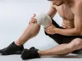 Uomo con ginocchio fasciato, pronto per esercizi per menisco lesionato.