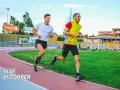 Due atleti si sfidano in un test di cooper scolastico su una pista di atletica.