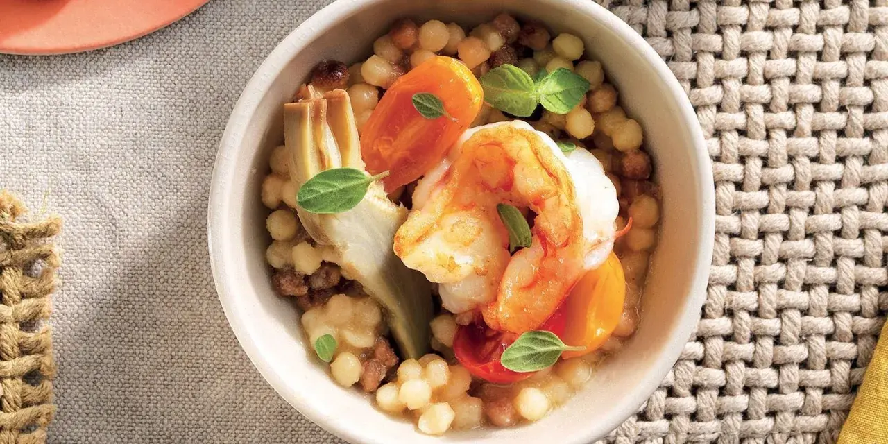 Gamberi e carciofi su couscous, un piatto gustoso e leggero, perfetto per le tue ricette con proteine.