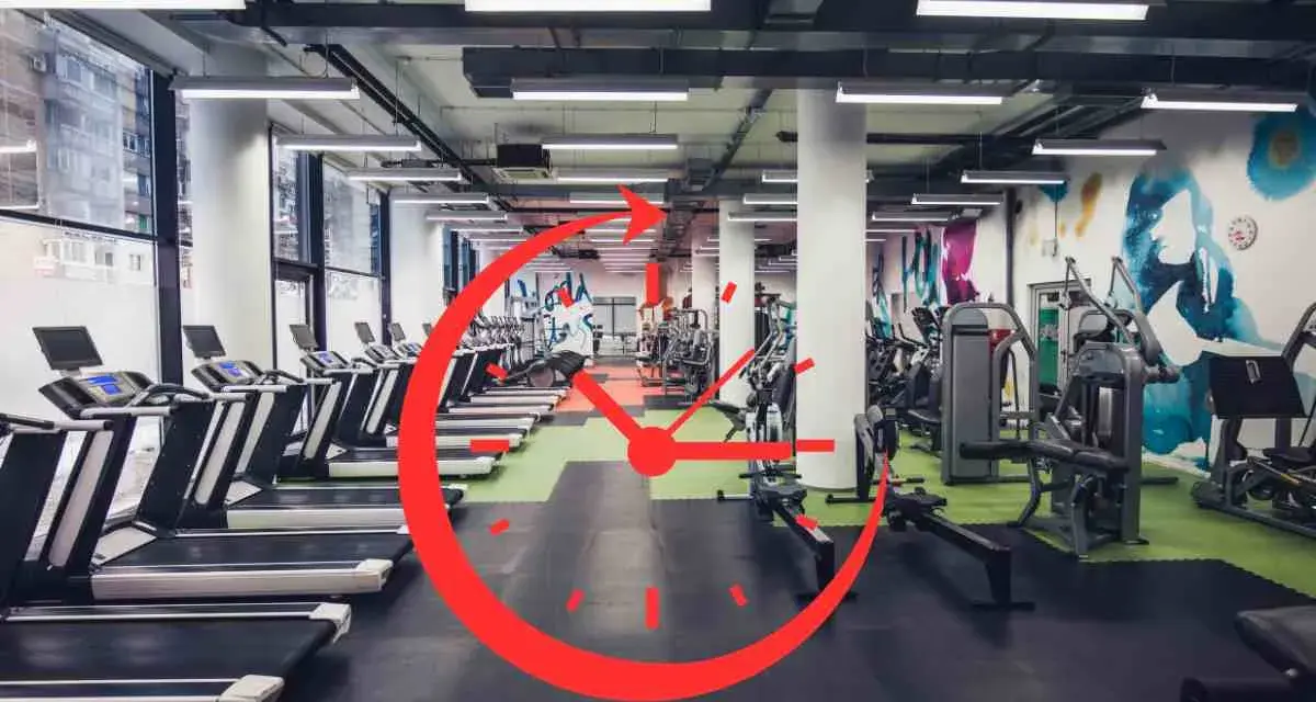 Una palestra moderna con tapis roulant e macchine per il fitness. Un grande orologio rosso sovrapposto suggerisce gli orari migliori per andare in palestra.
