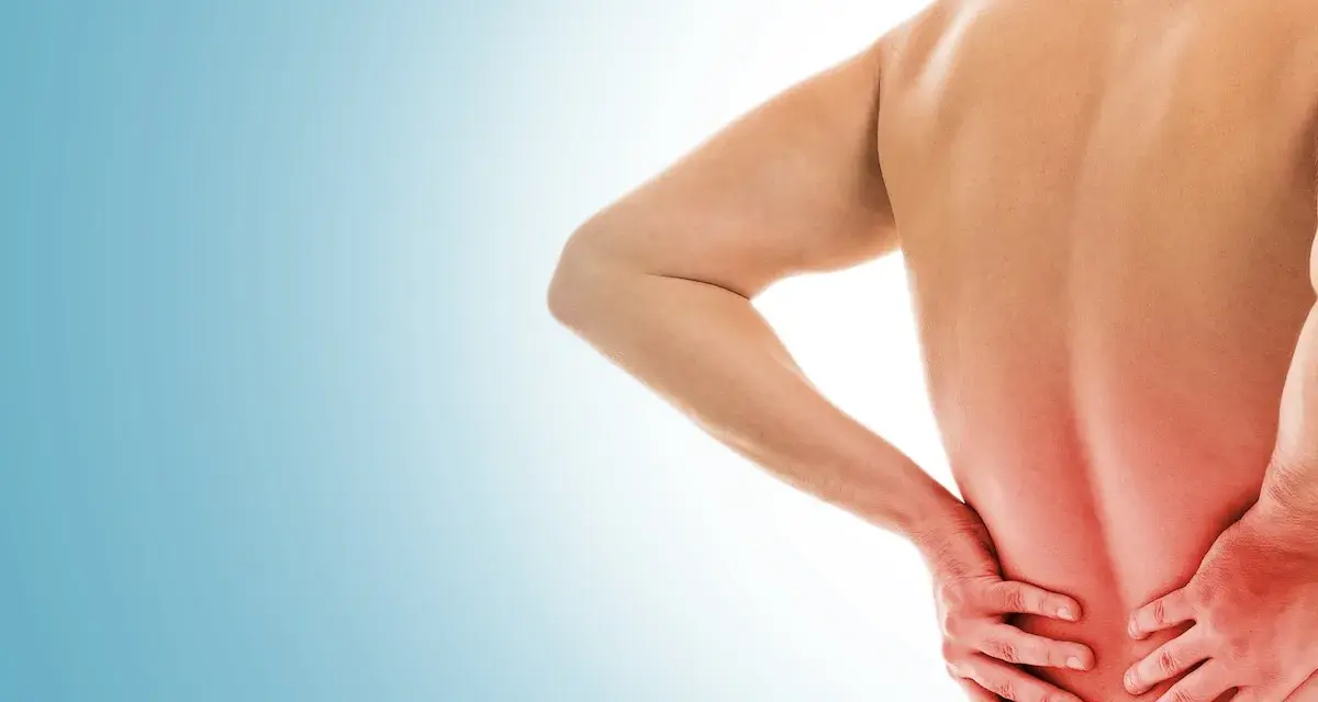 Uomo con mal di schiena, mani sulla zona dolente. Si discute di punture di cortisone per mal di schiena effetti collaterali.