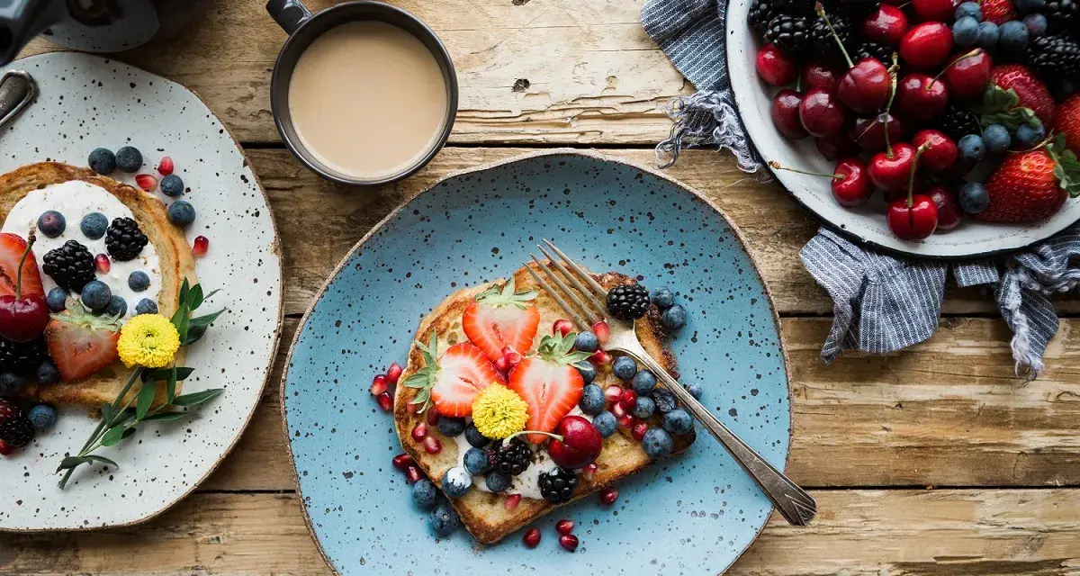 Toast con frutta fresca e yogurt, una colazione energetica per sportivi. Frutti di bosco, fragole e ciliegie per iniziare la giornata con vitalità.