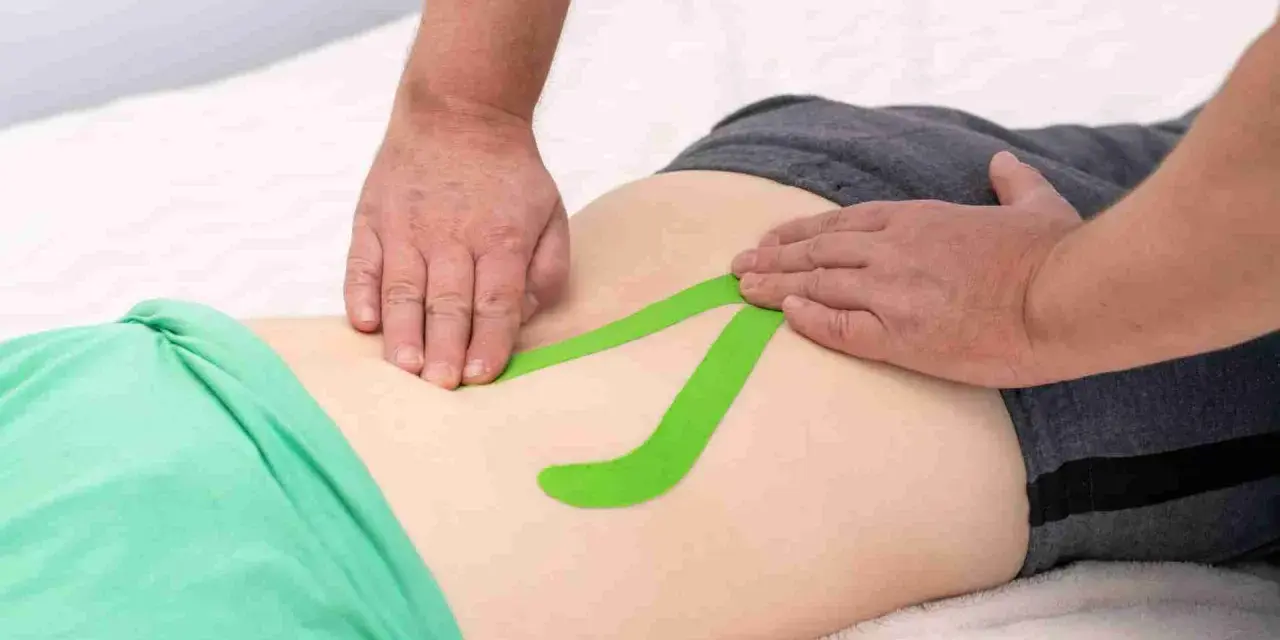 Applicazione di taping per un possibile strappo muscolare schiena bassa. Quanto dura il recupero?
