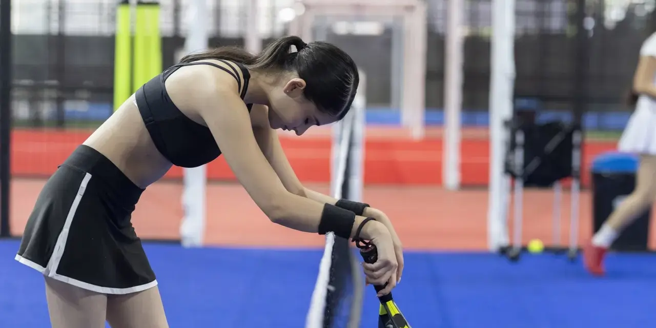 Giocatrice di padel esausta, forse cerca rimedi naturali per il dolore all'anca dopo l'allenamento.