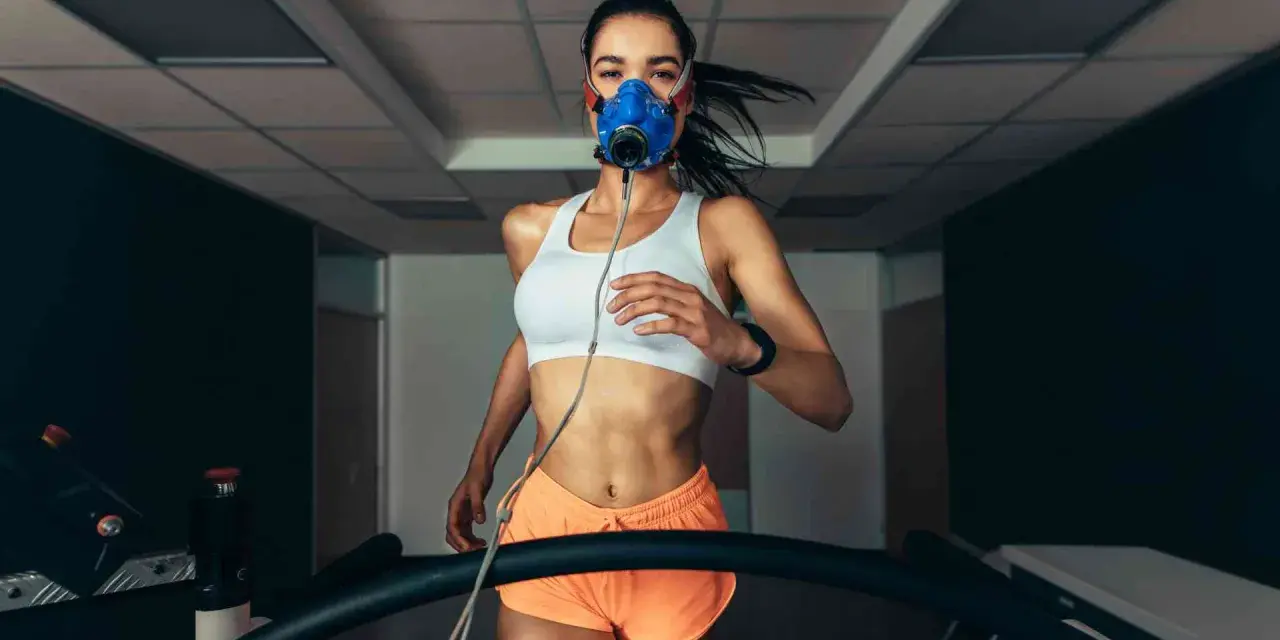 Donna corre su tapis roulant con maschera per misurare il VO2 max.