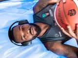 Giocatore di basket con cuffie e pallone, pronto per la preparazione fisica.