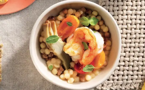 Gamberi e carciofi su couscous, un piatto gustoso e leggero, perfetto per le tue ricette con proteine.