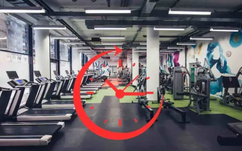 Una palestra moderna con tapis roulant e macchine per il fitness. Un grande orologio rosso sovrapposto suggerisce gli orari migliori per andare in palestra.
