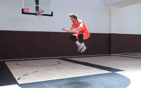 Atleta in aria, in pieno allenamento contro resistenza, su un campo da basket.