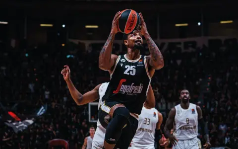 Giocatore di basket con la palla in alto, pronto al tiro. La folla sugli spalti è un tripudio di colori, un vero e proprio rapporto calorico di emozioni.