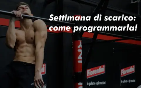 Uomo muscoloso alla sbarra, pronto per la sua settimana di scarico. Impara come programmarla per recuperare al meglio.