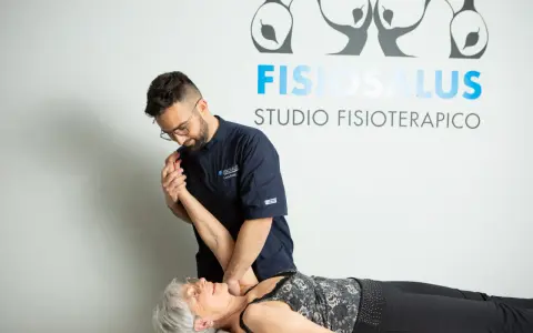 Fisioterapista esegue un trattamento per la fisioterapia della spalla a una paziente sdraiata.