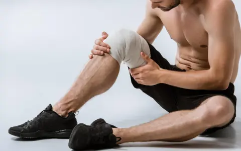 Uomo con ginocchio fasciato, pronto per esercizi per menisco lesionato.