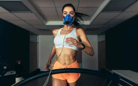 Donna corre su tapis roulant con maschera per misurare il VO2 max.