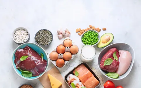 Varietà di alimenti ricchi di zinco: fegato, carne rossa, pollo, salmone, gamberi, uova, fagioli, semi di zucca, piselli, mandorle, avocado, formaggio, latte, aglio e grano saraceno.