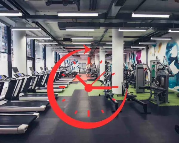 Una palestra moderna con tapis roulant e macchine per il fitness. Un grande orologio rosso sovrapposto suggerisce gli orari migliori per andare in palestra.