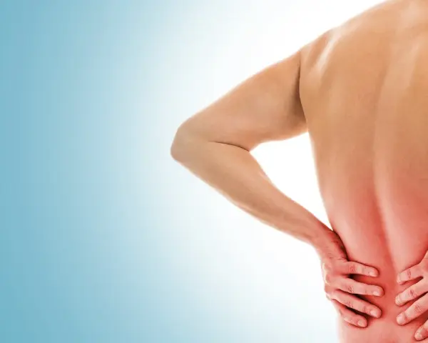Uomo con mal di schiena, mani sulla zona dolente. Si discute di punture di cortisone per mal di schiena effetti collaterali.
