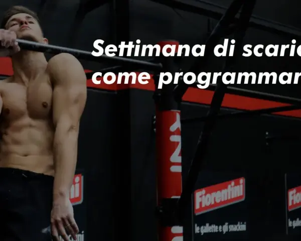 Uomo muscoloso alla sbarra, pronto per la sua settimana di scarico. Impara come programmarla per recuperare al meglio.