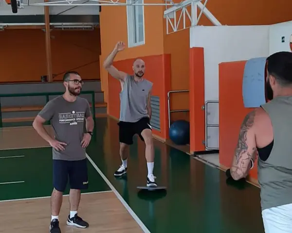 Allenamento in palestra: un uomo esegue torsioni del busto su una tavoletta di equilibrio, mentre un altro lo osserva.