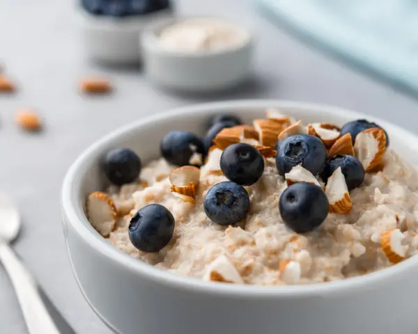 Porridge con mirtilli e mandorle, un'idea per ricette con proteine in polvere per una colazione sana e gustosa.