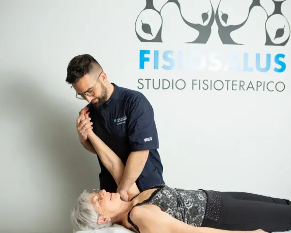 Fisioterapista esegue un trattamento per la fisioterapia della spalla a una paziente sdraiata.