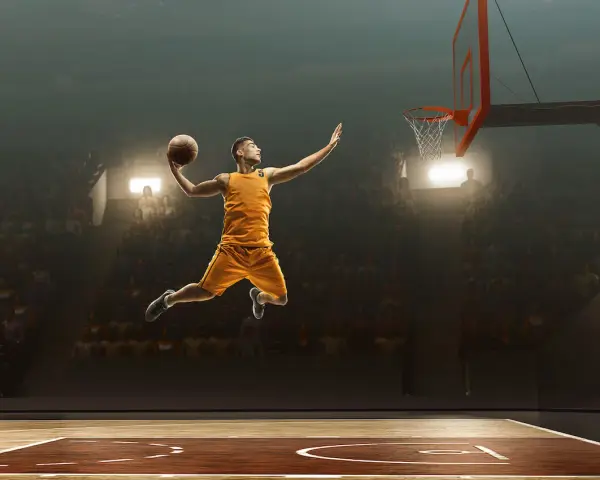 Un giocatore di basket in aria, pronto a schiacciare, sembra quasi fermo nel tempo per riprendere fiato prima del grande momento.