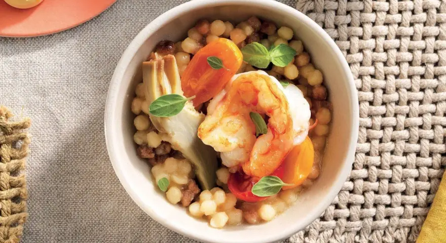 Gamberi e carciofi su couscous, un piatto gustoso e leggero, perfetto per le tue ricette con proteine.
