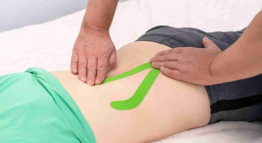 Applicazione di taping per un possibile strappo muscolare schiena bassa. Quanto dura il recupero?