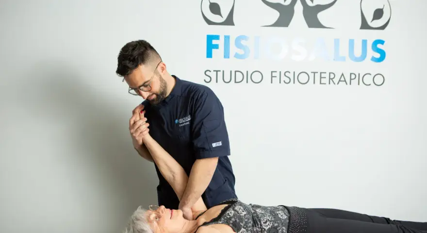 Fisioterapista esegue un trattamento per la fisioterapia della spalla a una paziente sdraiata.