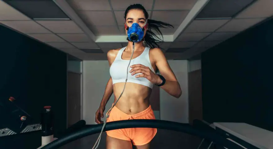 Donna corre su tapis roulant con maschera per misurare il VO2 max.