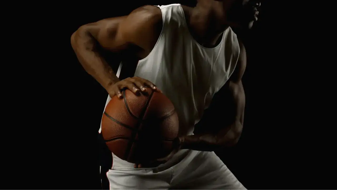 Giocatore di basket con palla, pronto a scattare. La sua postura è perfetta, frutto di attenti test posturali.