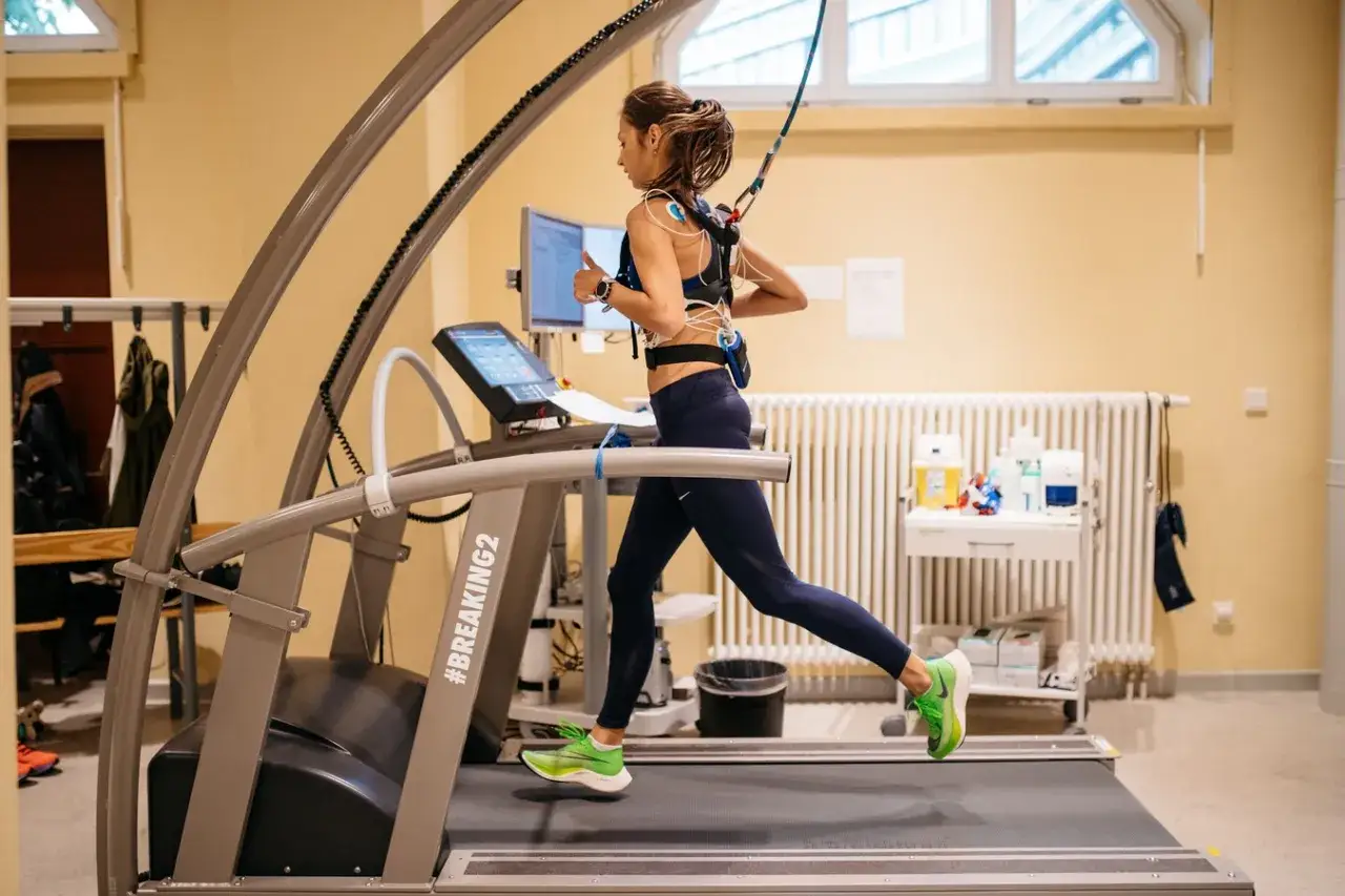 Donna corre su tapis roulant con elettrodi per misurare il VO2 max, cos'è il massimo consumo di ossigeno.