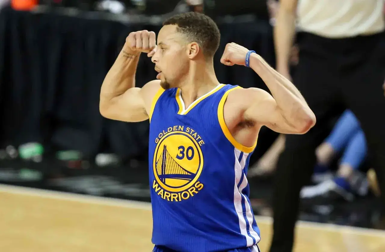 Stephen Curry mostra i suoi bicipiti, muscoli che gli danno la forza per segnare canestri per i Golden State Warriors.