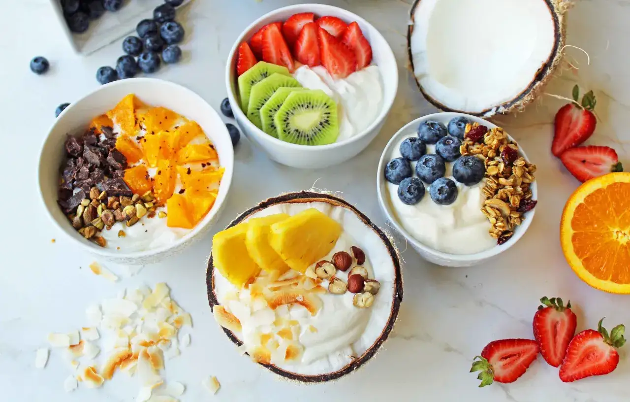 Yogurt greco propriet&agrave;: ciotole colorate con frutta fresca, cocco, granella e cioccolato. Un tripudio di gusto e benessere.