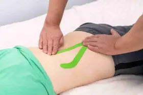 Applicazione di taping per un possibile strappo muscolare schiena bassa. Quanto dura il recupero?