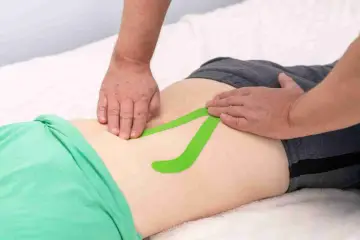 Applicazione di taping per un possibile strappo muscolare schiena bassa. Quanto dura il recupero?