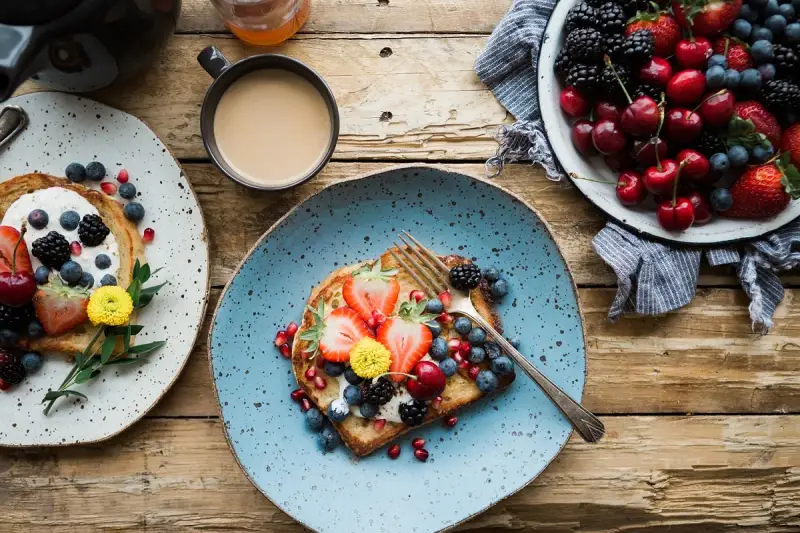 Toast con frutta fresca e yogurt, una colazione energetica per sportivi. Frutti di bosco, fragole e ciliegie per iniziare la giornata con vitalità.